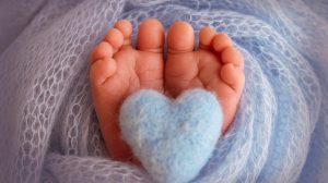A baby 's foot with a heart in it.